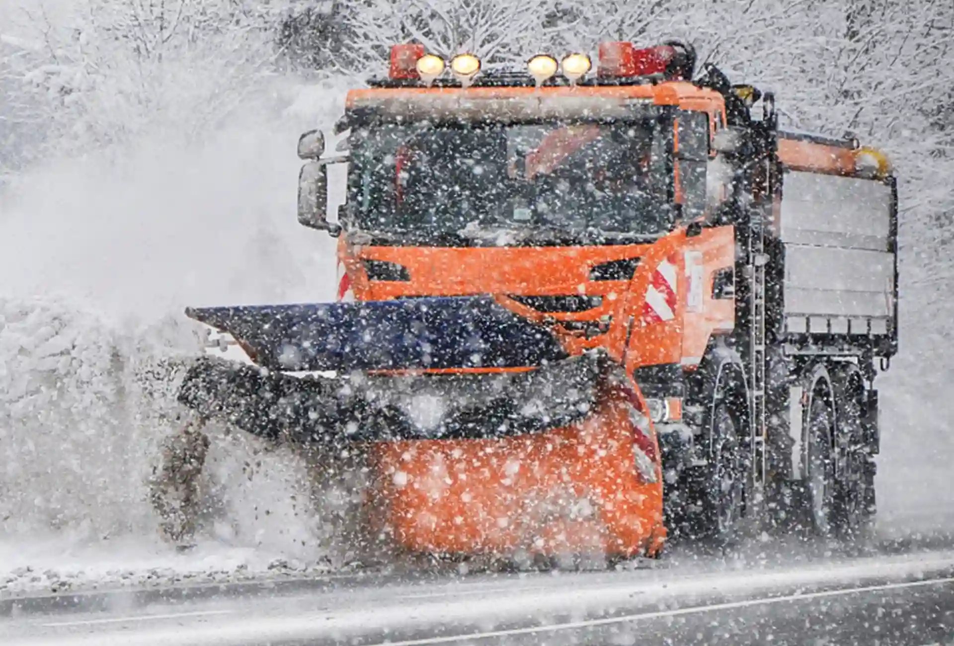 Snow plough working during winter storm