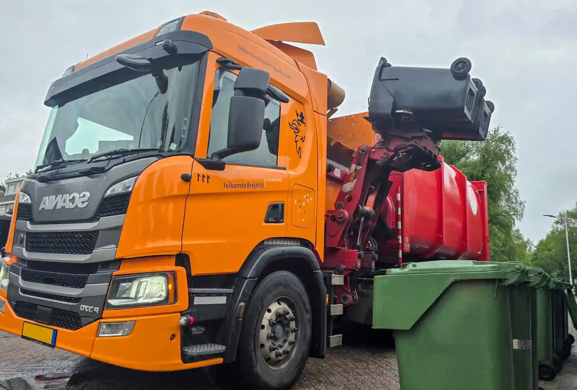 Waste collection side loader truck collecting waste  