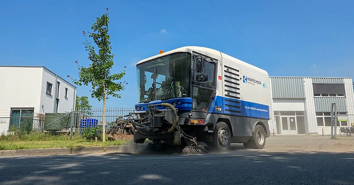 Street sweeping truck cleaning a road with Jewel software to manage street sweeping operations