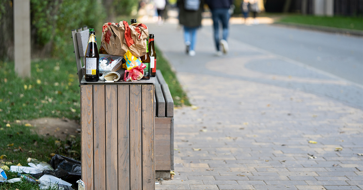 Overflowing litter bin in public space highlighting need for smarter waste and street cleaning management with Jewel software