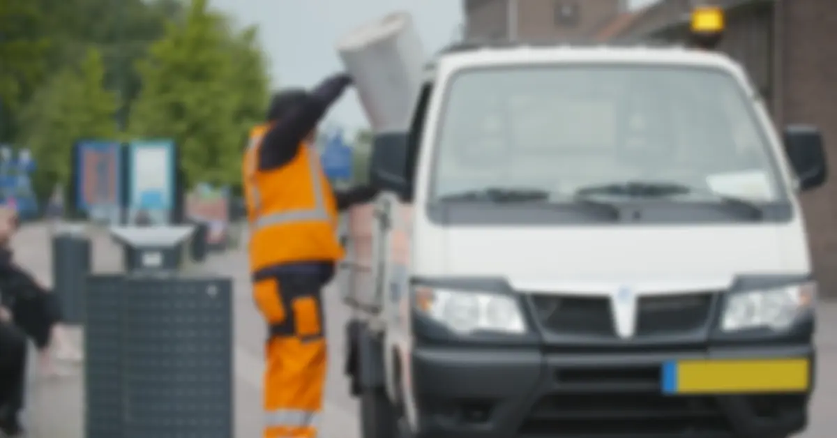 Experienced street cleansing worker emptying bin